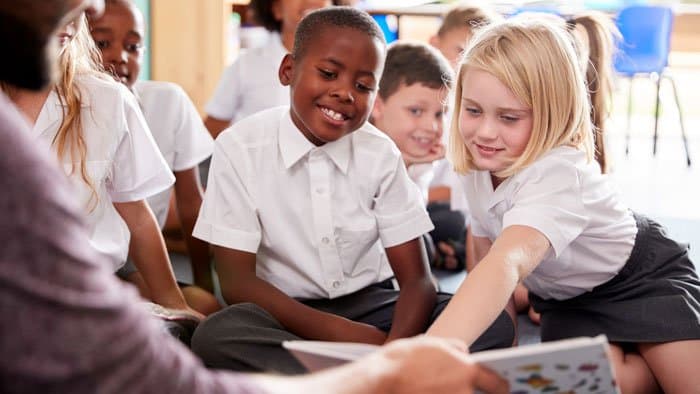 Reception kids listening to their teacher reading.